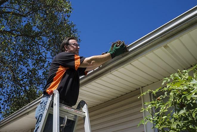 a worker using tools to fix a broken gutter in Alturas FL