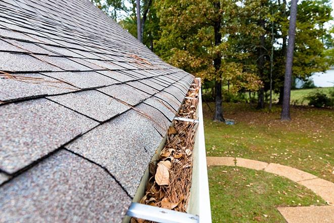 a roof with a gutter that is overflowing with leaves and debris